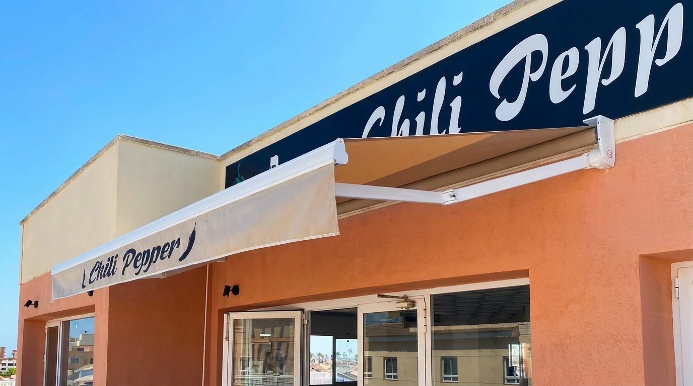 Toldo con faldón rotulado instalado en la fachada de un restaurante